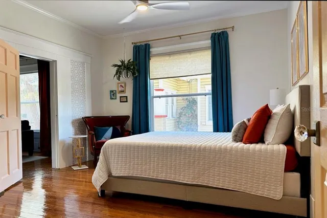 a bedroom with a bed and wooden floor