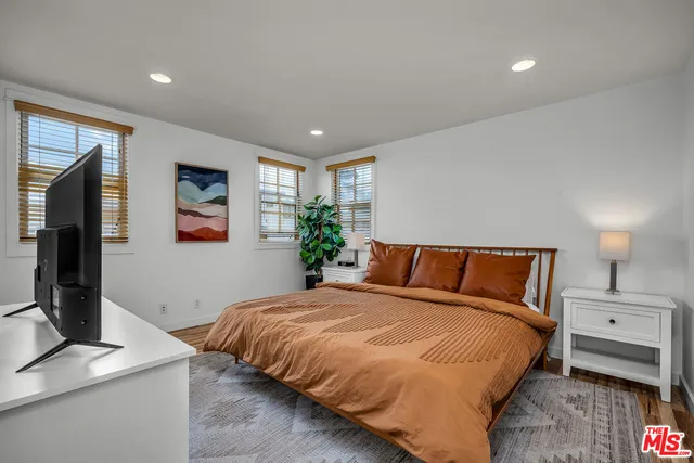 a large bedroom with a bed and a flat screen tv