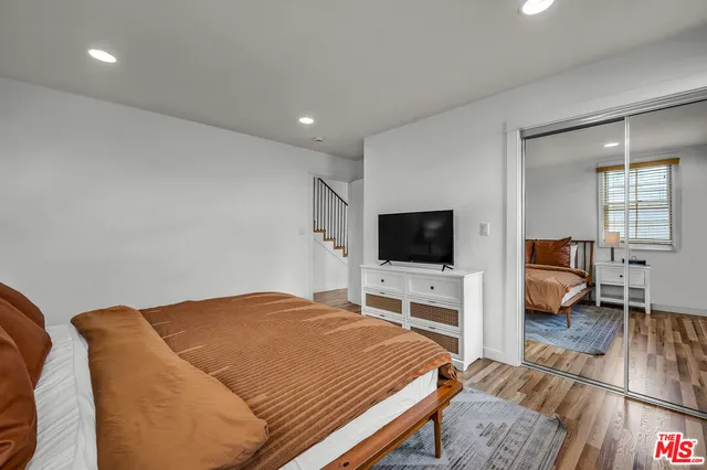 a bedroom with a bed and a flat screen tv