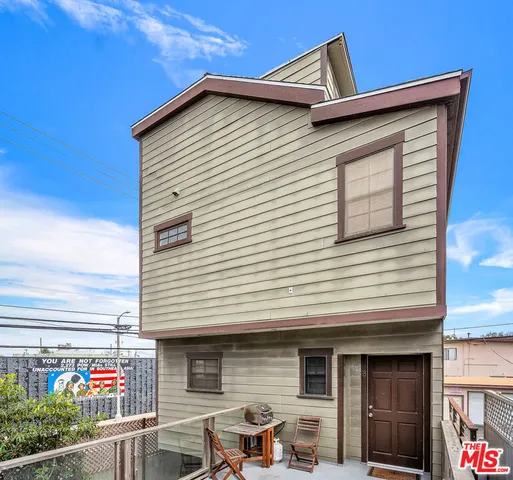 a front view of a house with plants