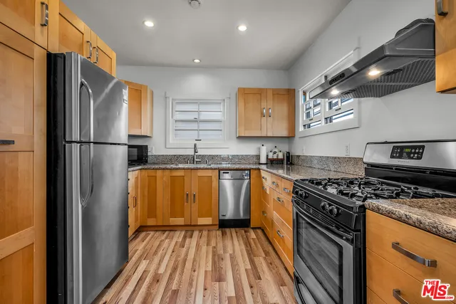 a kitchen with stainless steel appliances granite countertop a refrigerator and a sink