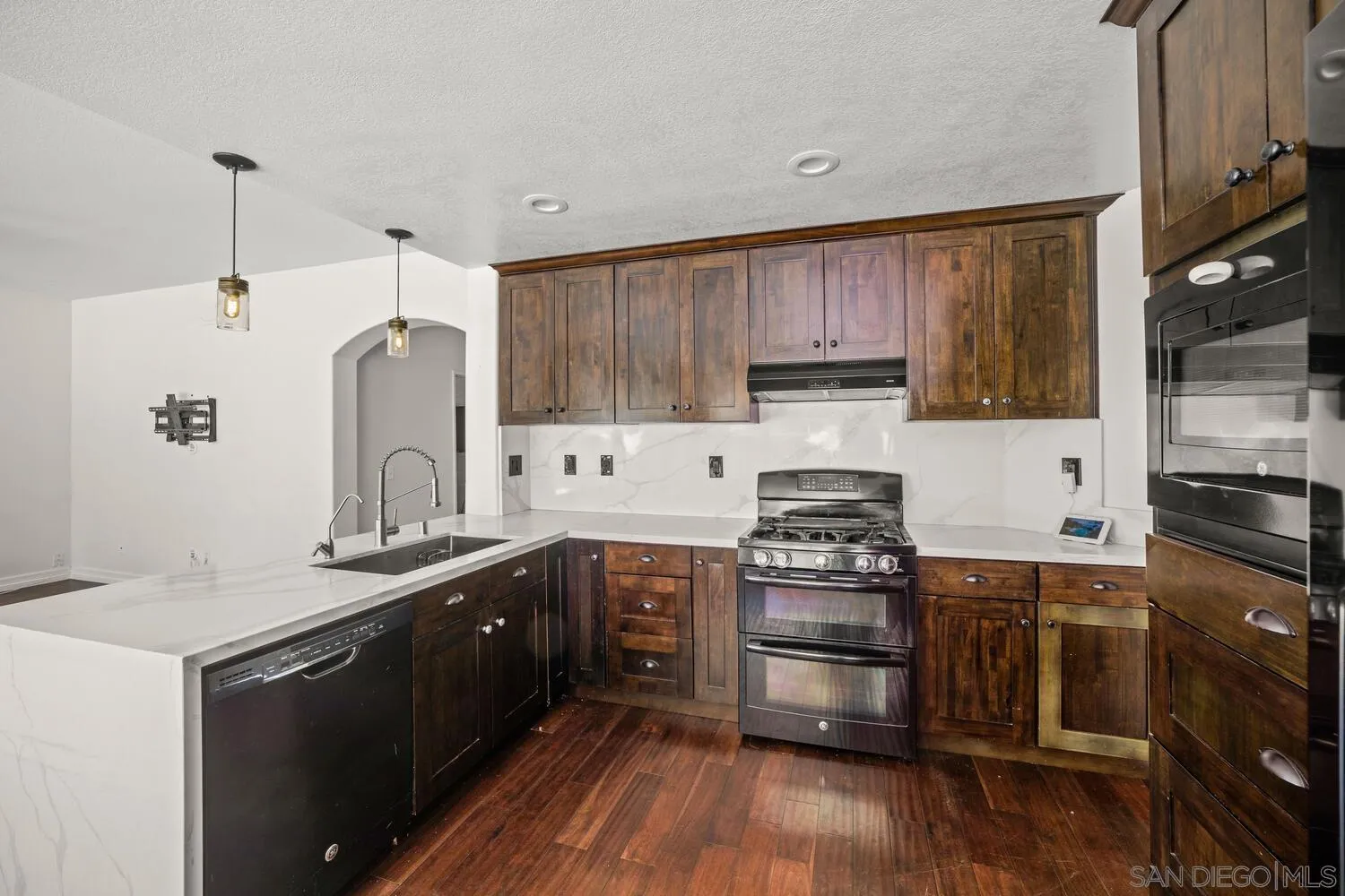 1690 Mountain Pass Circle Vista, CA 92081 - Photo 18 of 46 a kitchen with granite countertop a sink and steel appliances