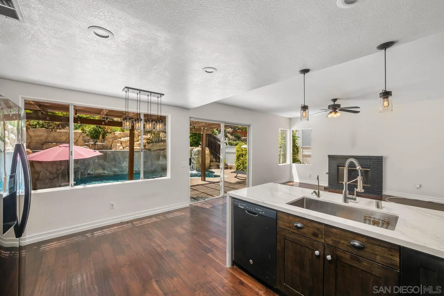 1690 Mountain Pass Circle Vista, CA 92081 - Photo 19 of 46 a large kitchen with kitchen island a large window a sink and stainless steel appliances