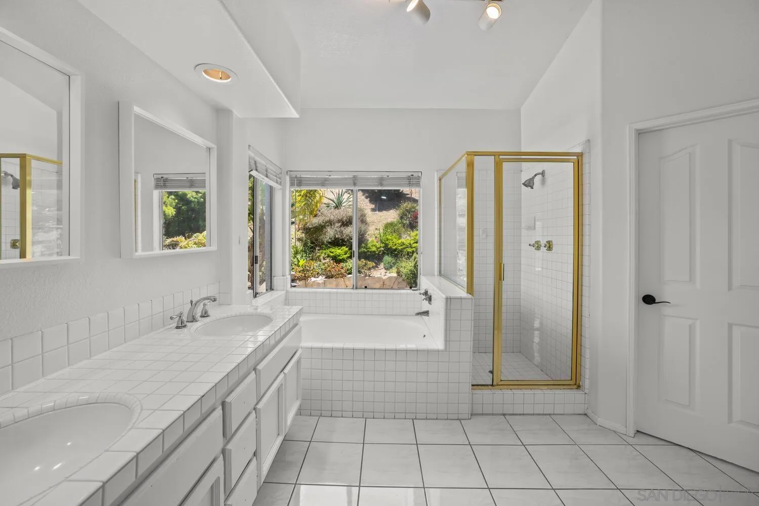 1690 Mountain Pass Circle Vista, CA 92081 - Photo 29 of 46 a spacious bathroom with a granite countertop shower a mirror and a sink