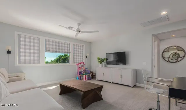 a view of a workspace with furniture and a window