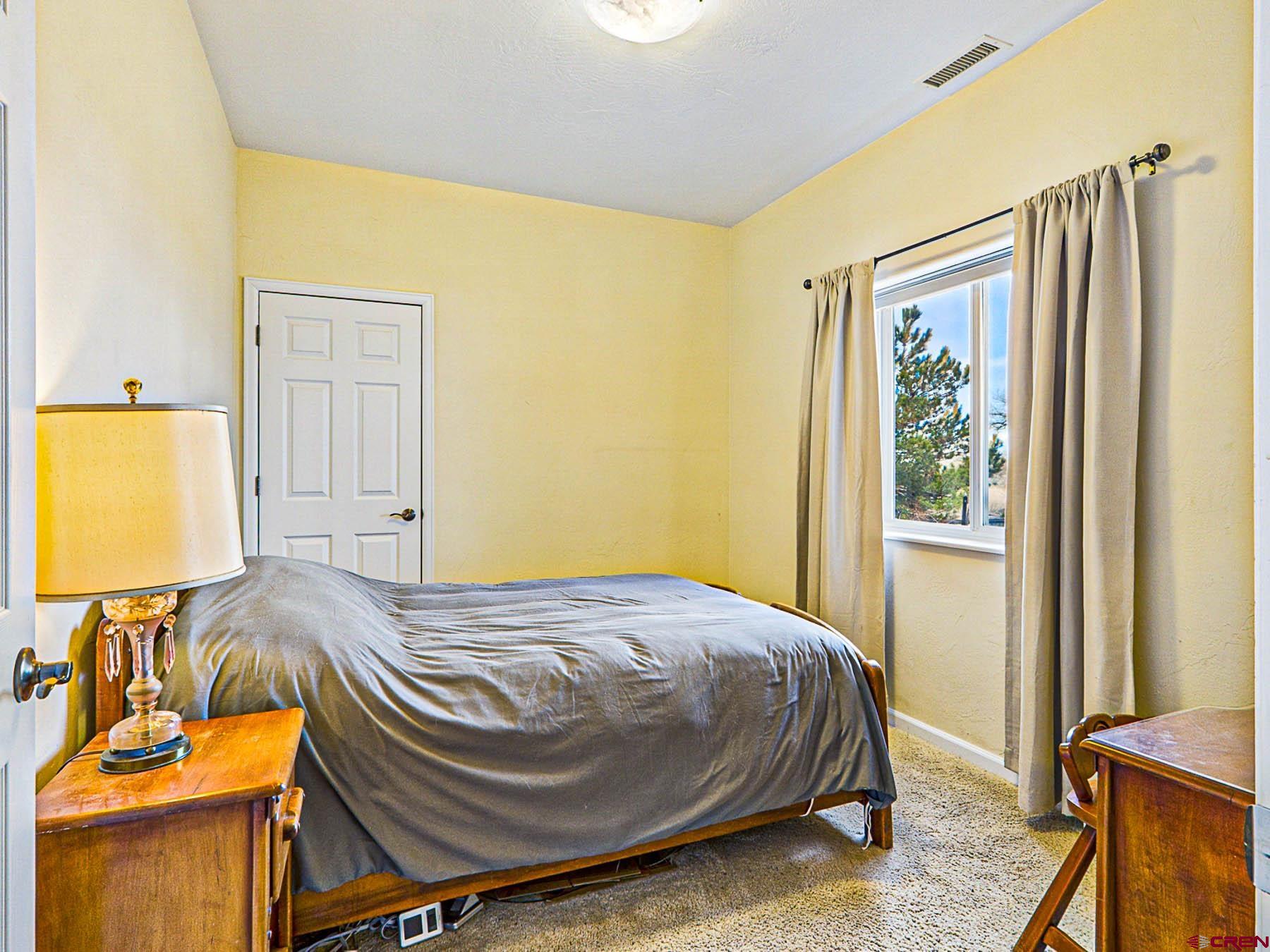 12689 6100th Road Montrose, CO 81403 - Photo 17 of 45 a bedroom with a bed and wooden floor