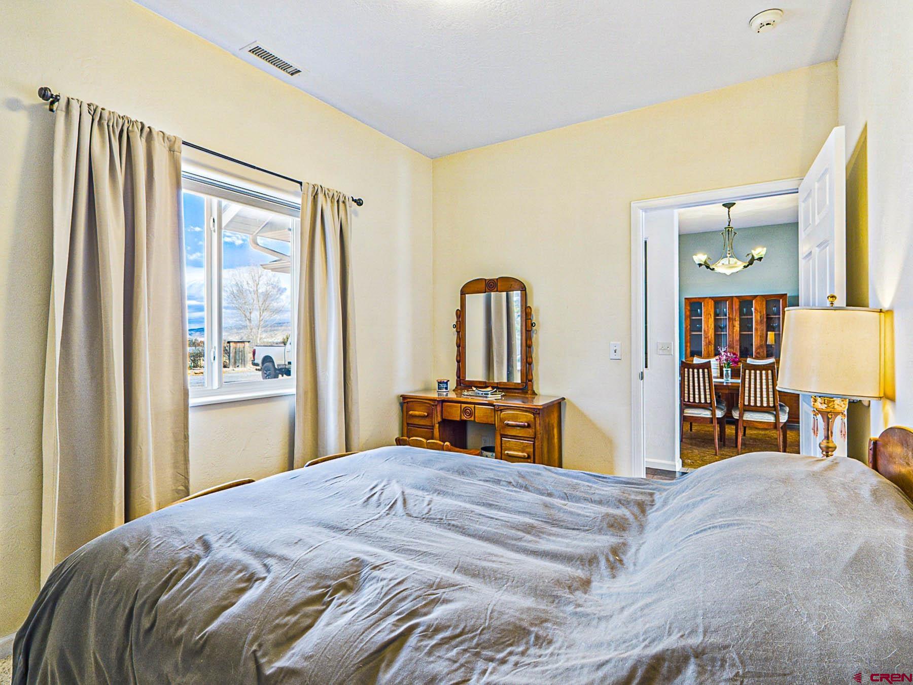 12689 6100th Road Montrose, CO 81403 - Photo 18 of 45 a bedroom with a bed and a dresser with mirror