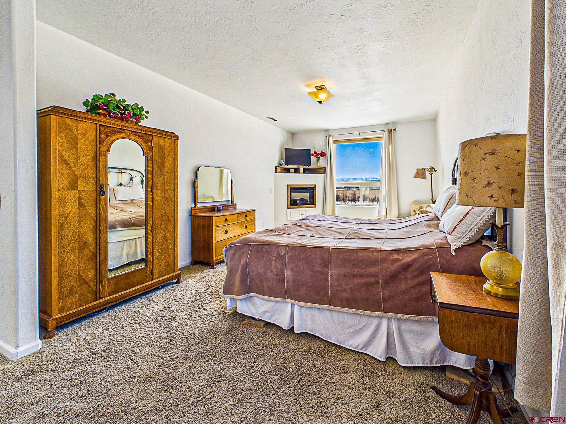 12689 6100th Road Montrose, CO 81403 - Photo 21 of 45 a bedroom with a bed and dresser with mirror
