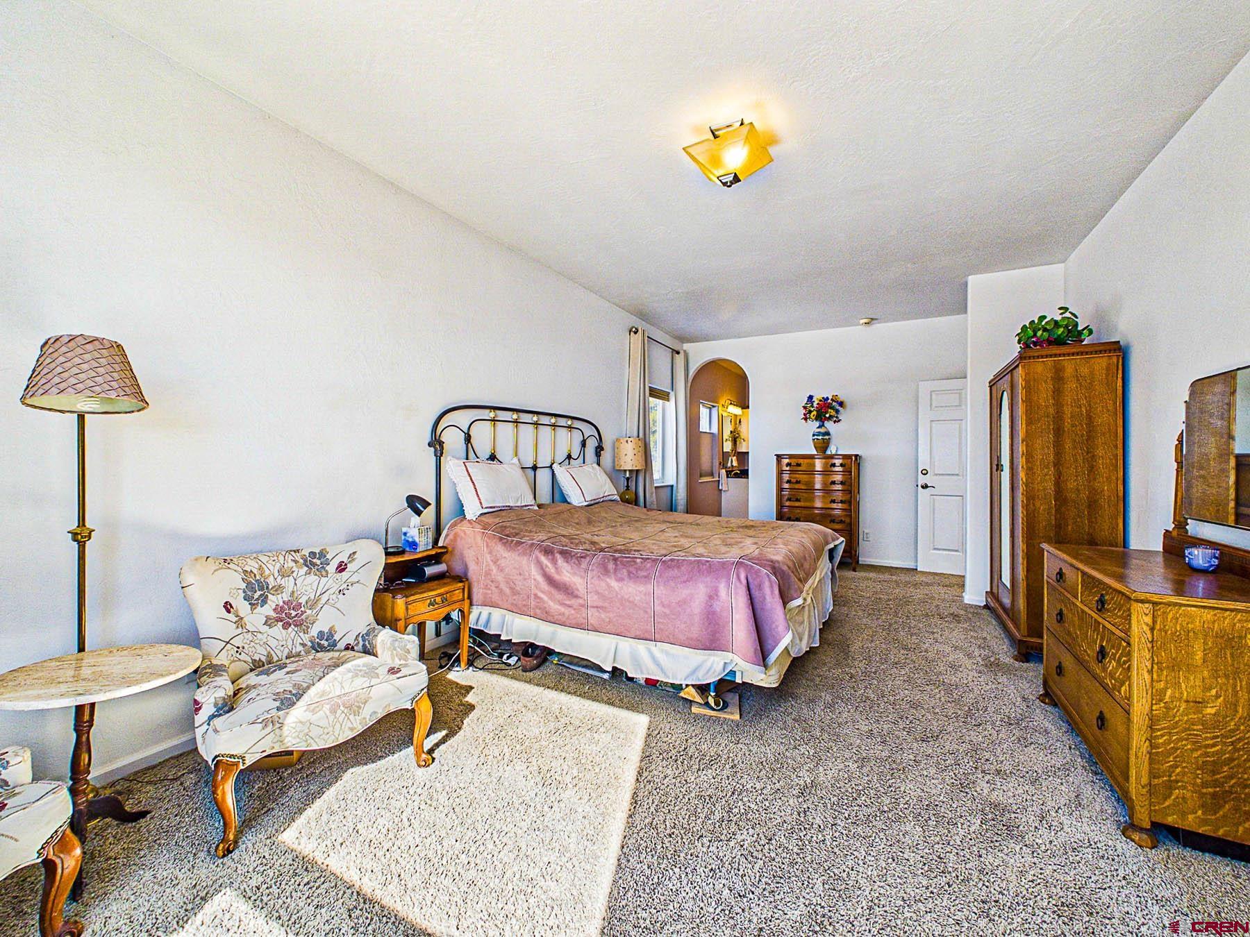12689 6100th Road Montrose, CO 81403 - Photo 22 of 45 a bedroom with a bed and a chandelier