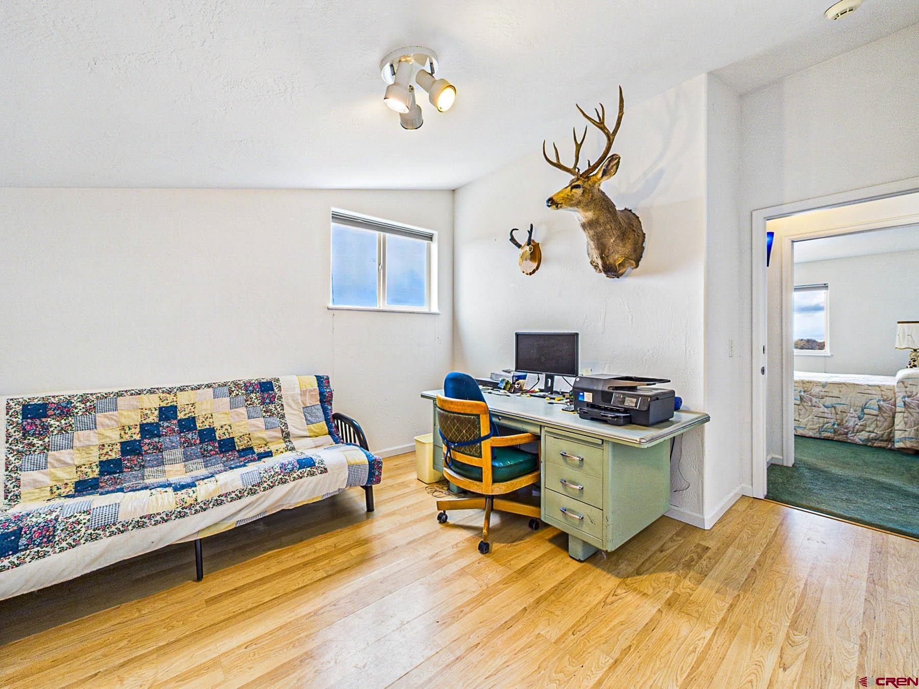 12689 6100th Road Montrose, CO 81403 - Photo 26 of 45 a bedroom with a bed and a chandelier