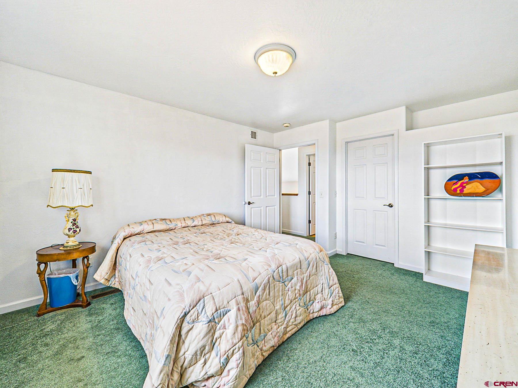 12689 6100th Road Montrose, CO 81403 - Photo 27 of 45 a bedroom with a bed and a chandelier