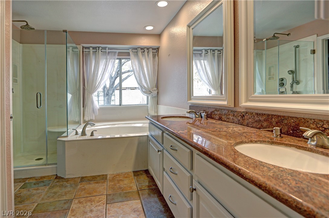 2108 Crestpoint Way Las Vegas, NV 89134 - Photo 15 of 27 Luxurious primary bath with a spacious soaking tub, separate shower, and dual vanities.