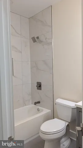 a white toilet and tub sitting next to a bathroom sink