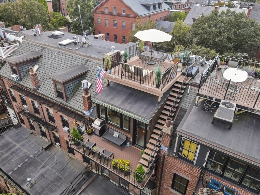 59 Rutland Street, Unit 3 Boston, MA 02118 - Photo 34 of 40 a view of a patio with table and chairs with wooden floor and fence