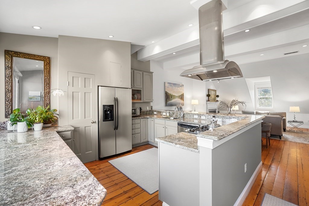 59 Rutland Street, Unit 3 Boston, MA 02118 - Photo 9 of 40 a kitchen with stainless steel appliances kitchen island granite countertop a refrigerator a stove a sink and a dining table with wooden floor
