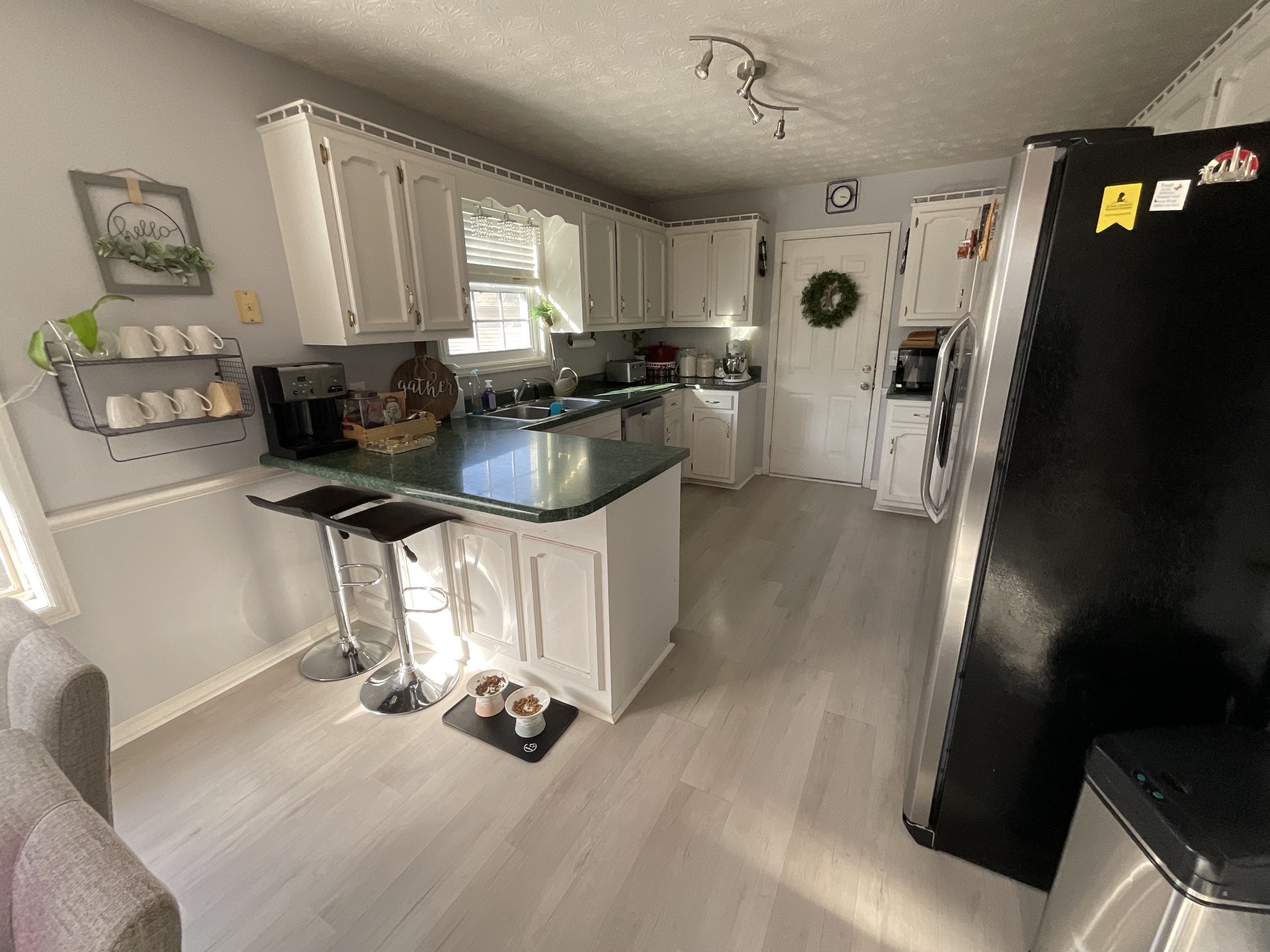110 Indian Pointe Drive White House, TN 37188 - Photo 7 of 19 a kitchen with stainless steel appliances granite countertop a refrigerator a sink dishwasher a stove a microwave oven and a dining table with wooden floor