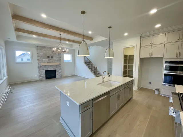 a large kitchen with kitchen island a sink stainless steel appliances and a counter top