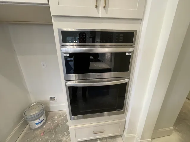 a stove top oven sitting inside of a kitchen