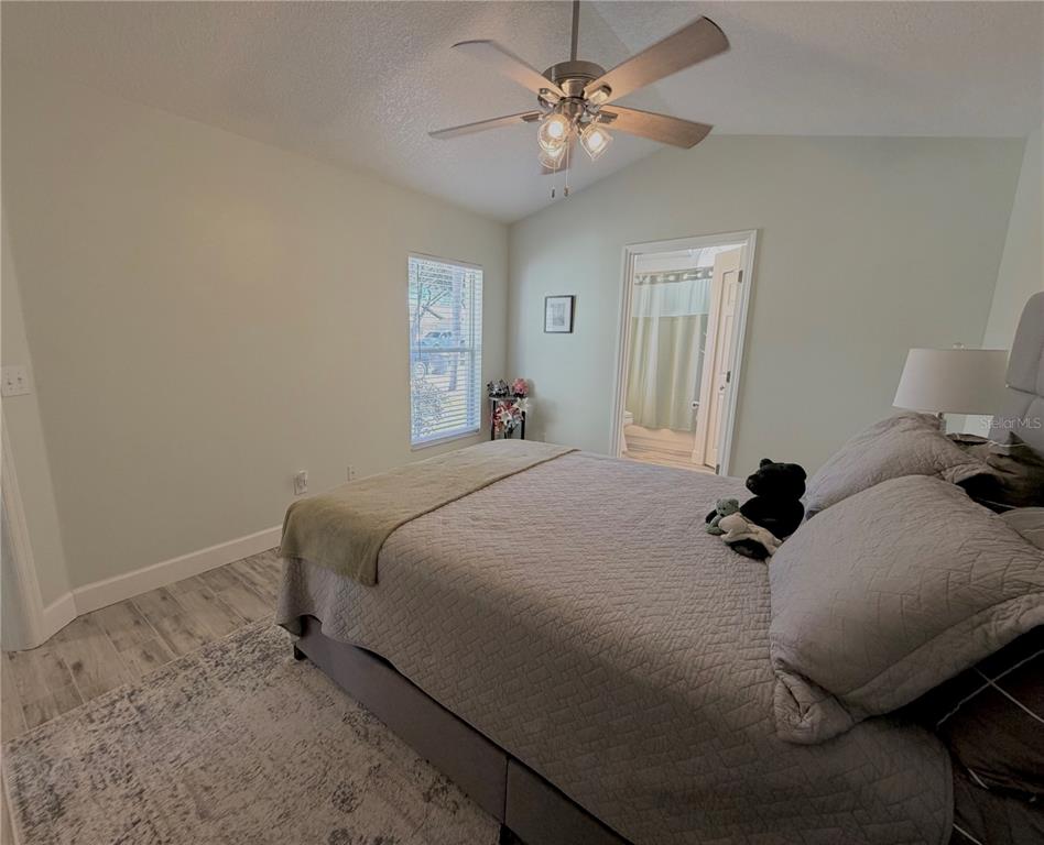 1332 Dew Bloom Road Valrico, FL 33594 - Photo 11 of 22 a bedroom with a bed and a chandelier