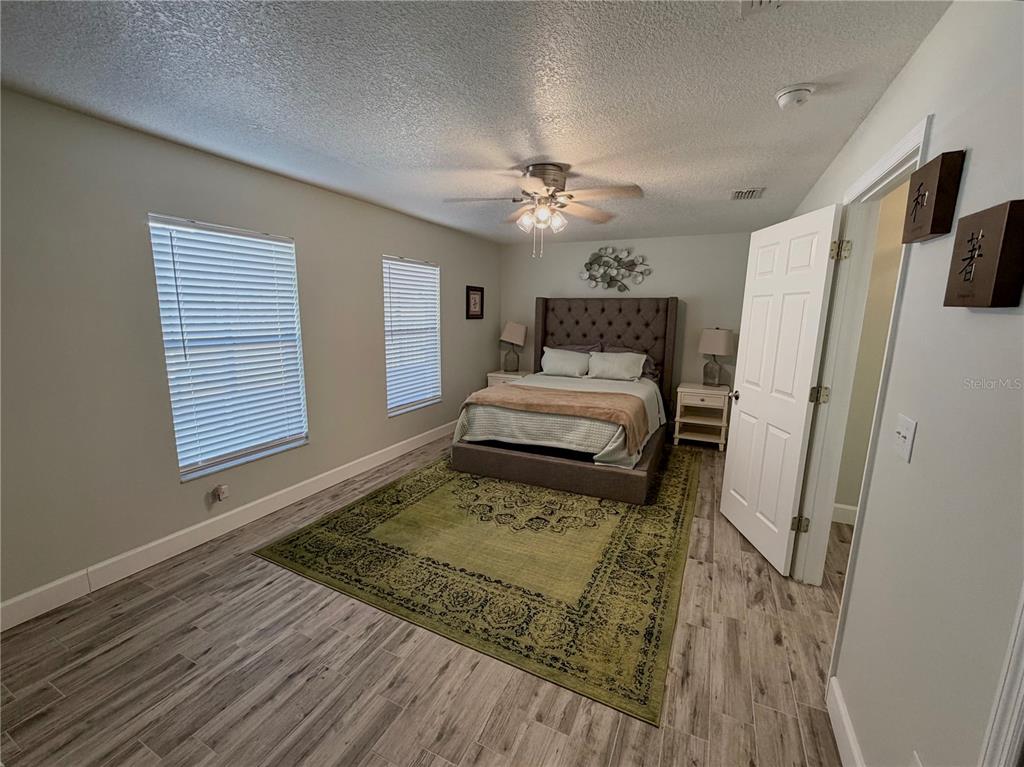 1332 Dew Bloom Road Valrico, FL 33594 - Photo 16 of 22 a bedroom with a bed and a chandelier