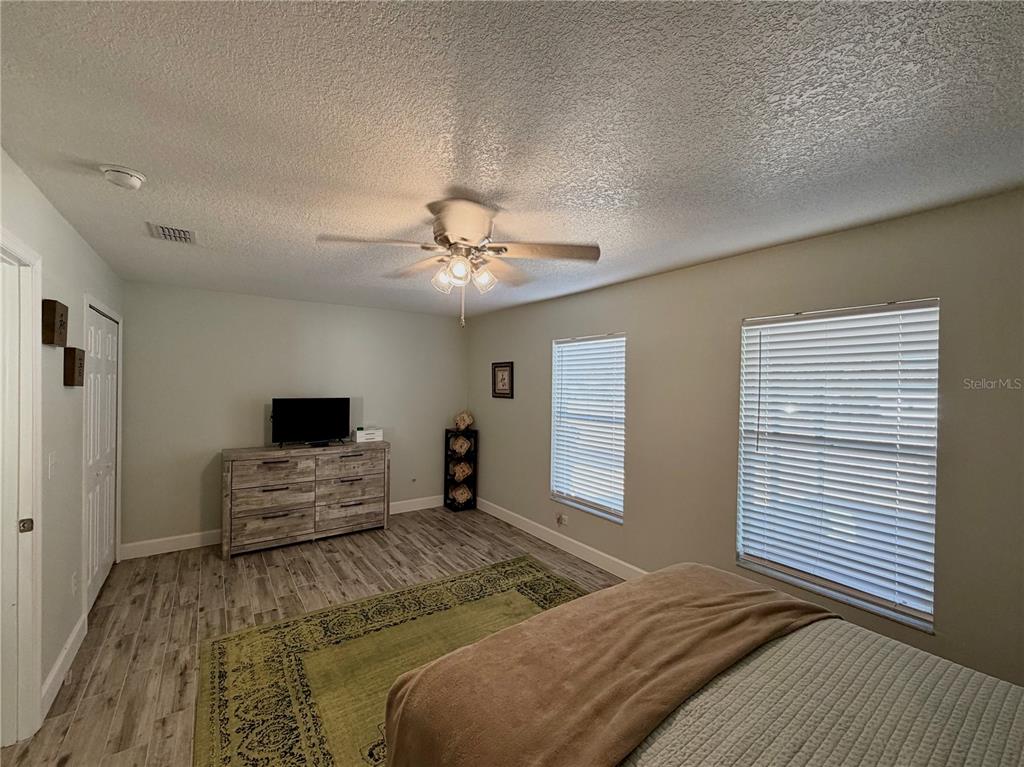 1332 Dew Bloom Road Valrico, FL 33594 - Photo 17 of 22 a bedroom with a bed and a flat screen tv