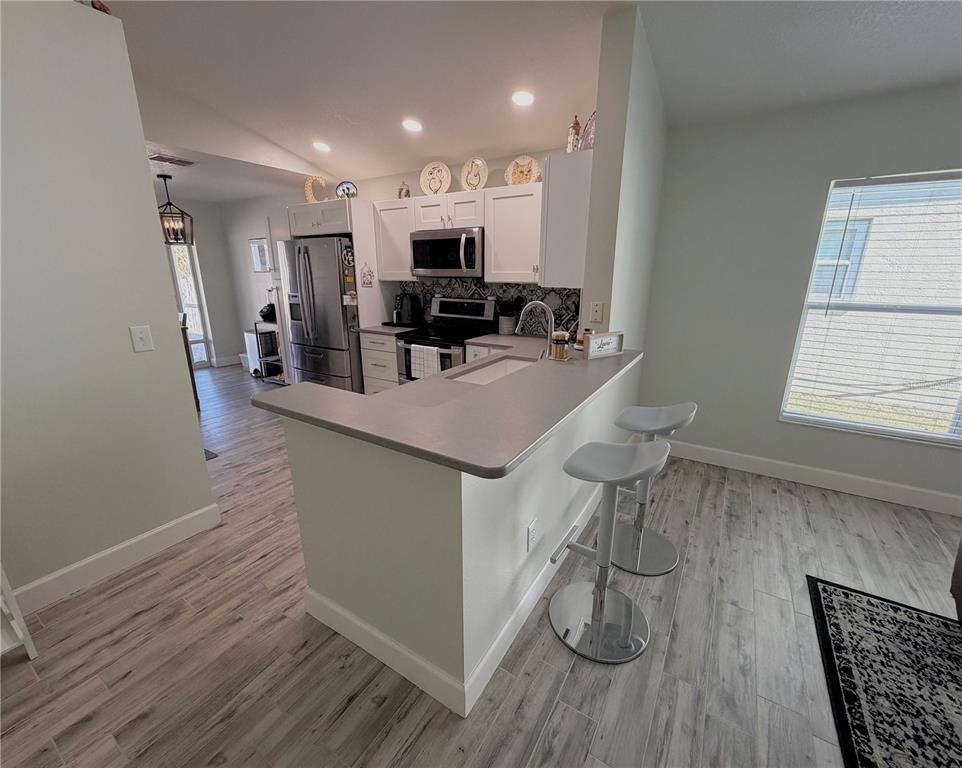 1332 Dew Bloom Road Valrico, FL 33594 - Photo 4 of 22 a kitchen with stainless steel appliances granite countertop a refrigerator a stove and a wooden floors