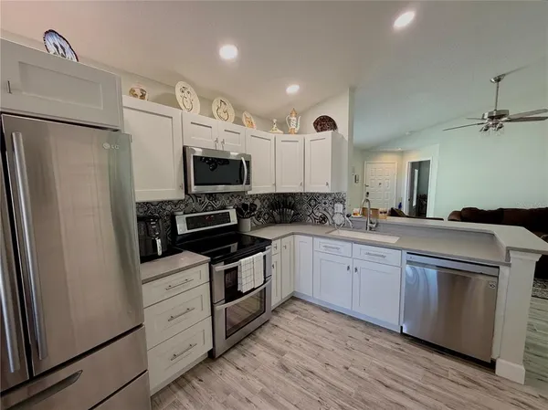 a kitchen with granite countertop a refrigerator stove and sink