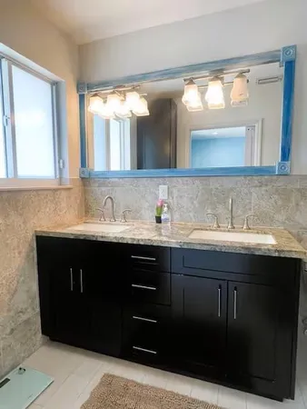 a bathroom with a sink vanity and mirror