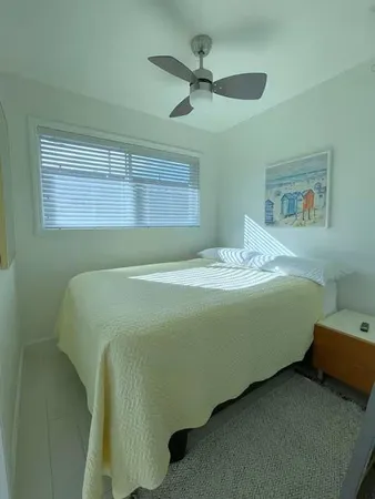 a bedroom with a bed and a ceiling fan