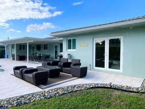 a view of a house with backyard sitting area and swimming pool