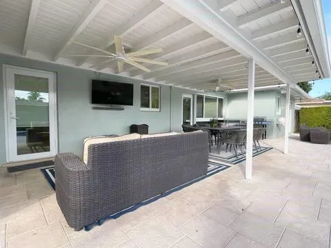a living room with furniture a flat screen tv and a large window