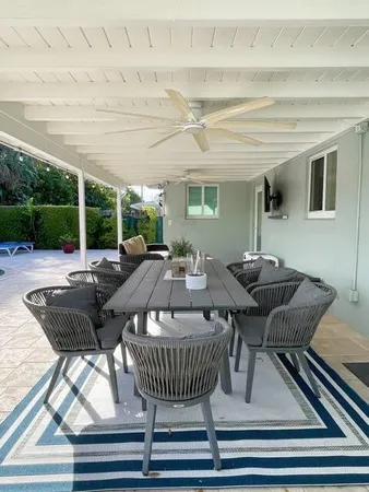 a view of a patio with table and chairs with wooden floor and fence
