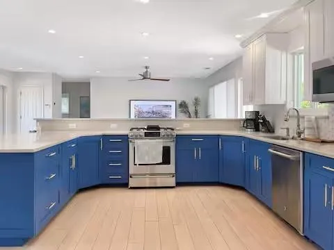 a kitchen with stainless steel appliances granite countertop a stove a sink dishwasher and a microwave oven with large cabinets