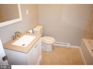a bathroom with a sink a toilet and mirror