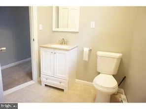 a bathroom with a toilet a sink and mirror