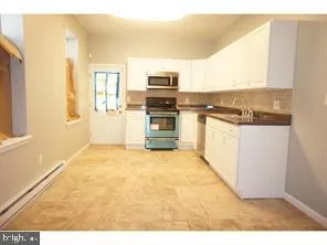 a view of a kitchen with wooden floor and a window