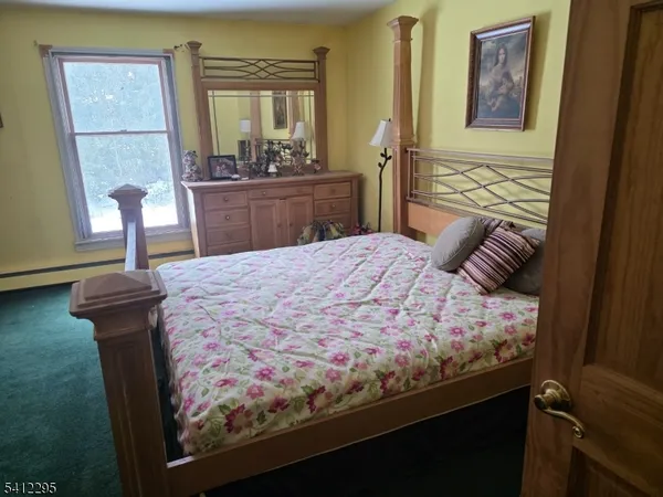 a bedroom with a bed and dresser with mirror