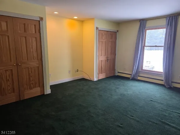 an empty room with windows and closet