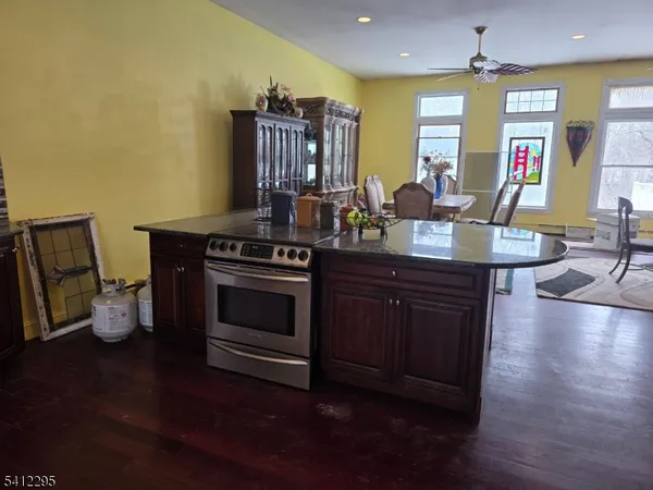 a kitchen with a stove and wooden floor
