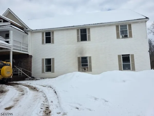 a view of a house with snow in front of house