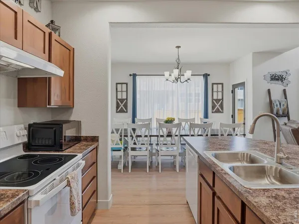 a kitchen with granite countertop a sink stove and cabinets