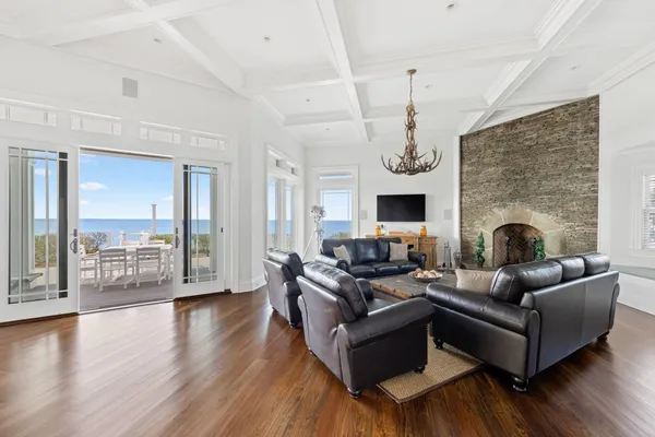 a living room with furniture a fireplace and a chandelier