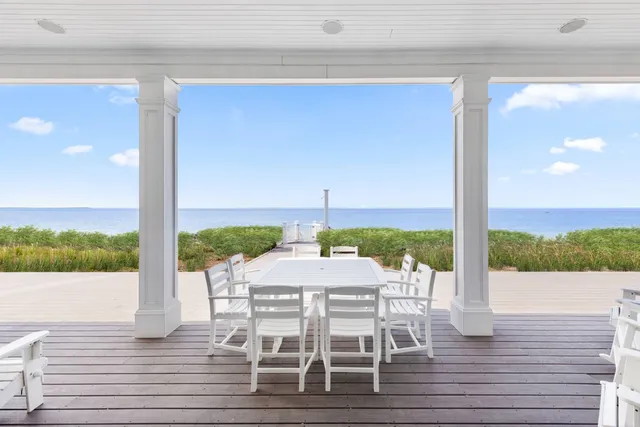 a view of a patio with a table chairs and wooden floor