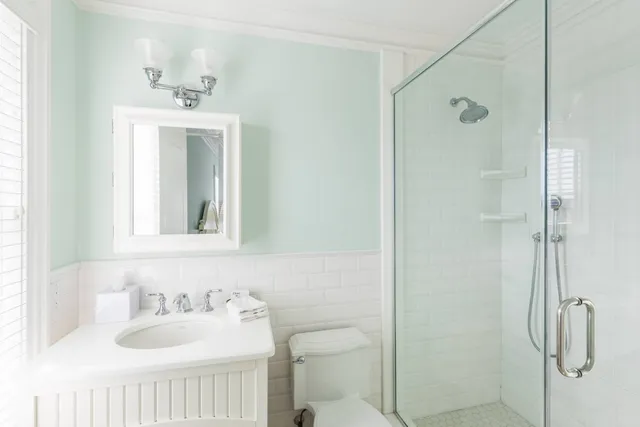 a bathroom with a sink a toilet and shower