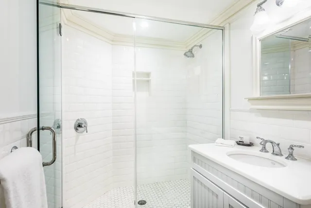 a bathroom with a granite countertop shower sink and mirror