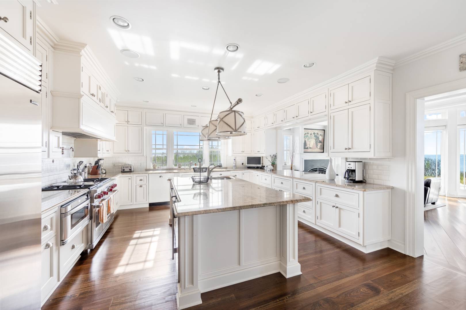 351 Kings Point Road East Hampton, NY 11937 - Photo 7 of 34 a large kitchen with kitchen island white cabinets and wooden floor
