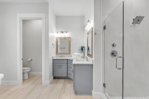 a bathroom with a granite countertop sink toilet and shower