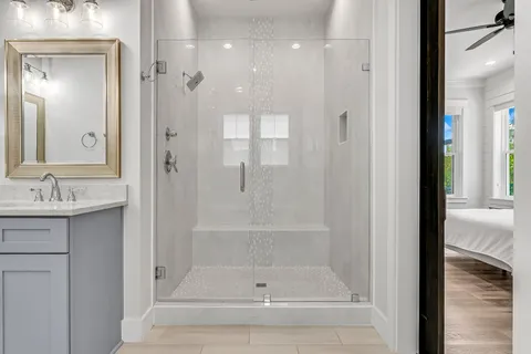 a bathroom with a shower a sink and a mirror