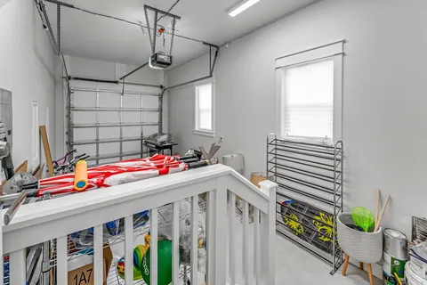 a room with lots of white furniture and a chandelier