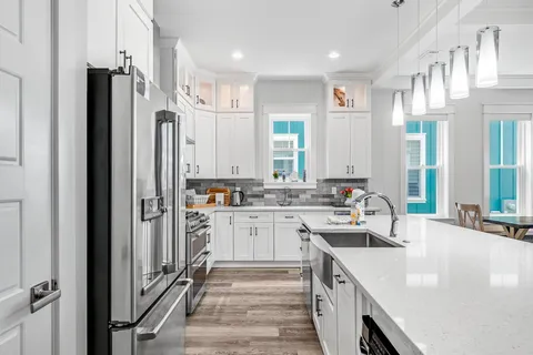 a kitchen with stainless steel appliances granite countertop a sink stove and refrigerator